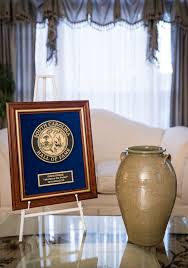 Award displayed next to a pottery jar